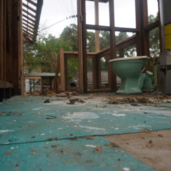 North Rocks, NSW 2151 14 An indoor area with debris on the floor, partially constructed walls, a green toilet, and a water heater, likely undergoing renovation or home demolitions.