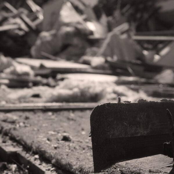 Burwood, NSW 2134 8 Sepia-toned image showing debris and damaged materials scattered in an area, possibly from home demolitions or a collapsed structure. Broken wood and metal pieces are in the foreground.